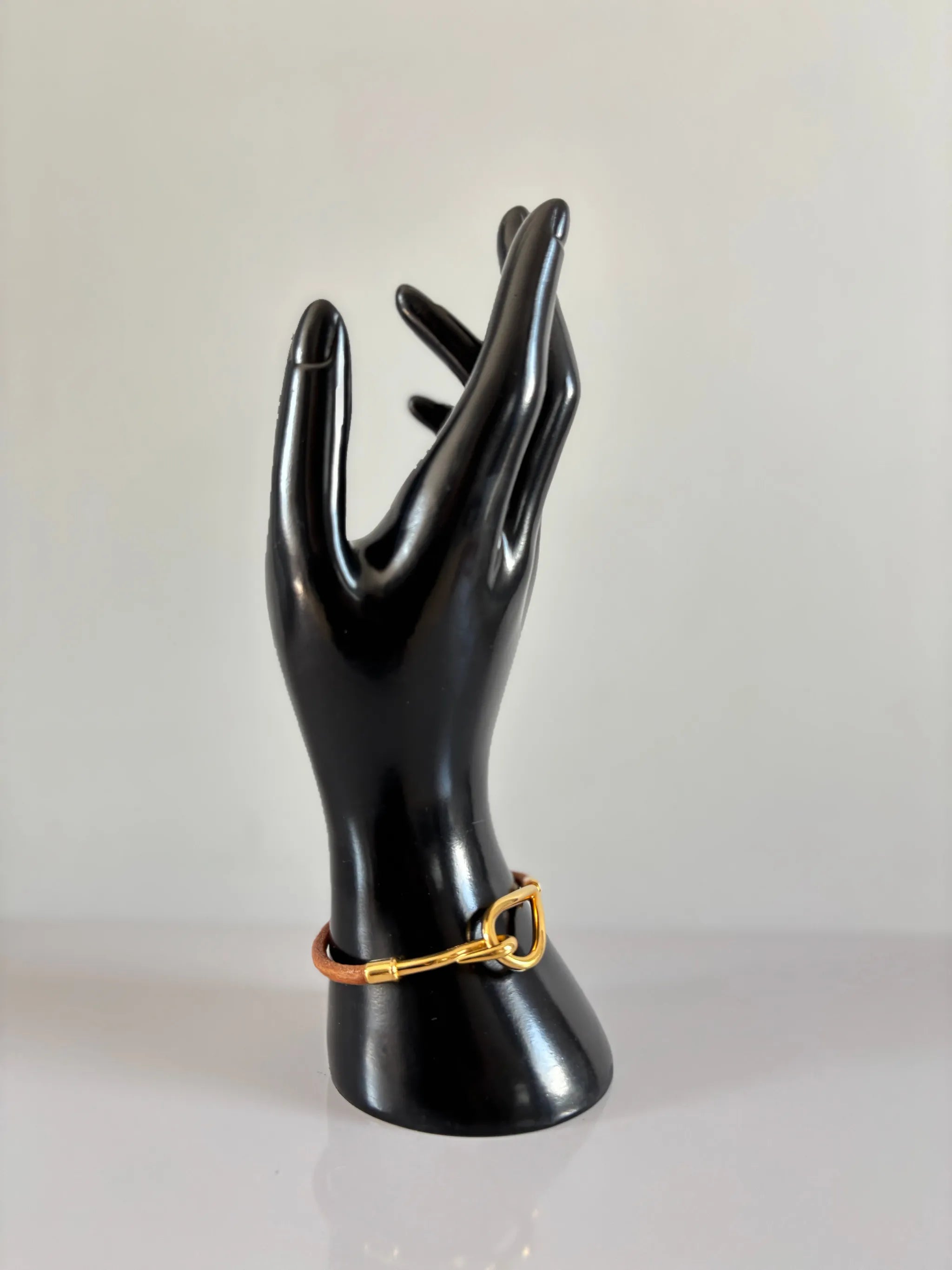 Bracelet jumbo en cuir naturel avec fermoir en métal doré, élégant et classique.